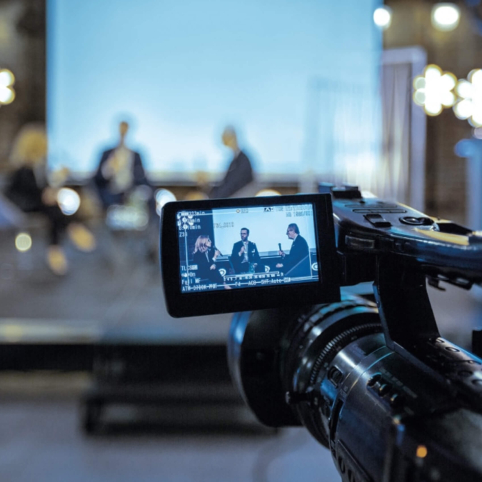 People being interviewed through the lens of a camera