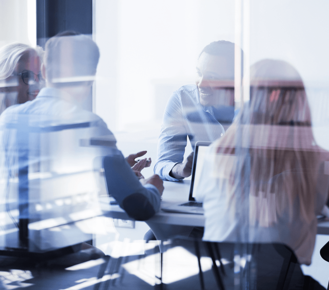 A group of office workers sit around a table generating ideas